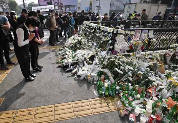梨泰院附近的车站周二堆满鲜花，民众为遇难者致敬。（法新社）