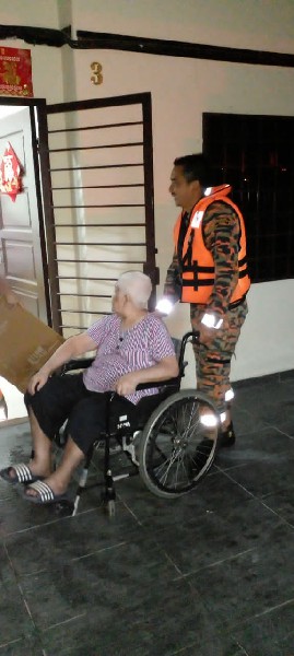 消拯员协助坐在轮椅上的老妇脱困。