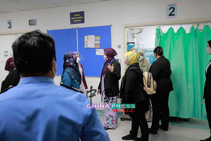 扎丽哈（中）在探望伤者时，向医护人员了解情况。