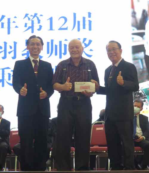 銮中董事长戴国光（右）及校长廖伟强（左）日前在毕业典礼上，颁发奖金给高秉益，祝贺他获奖。