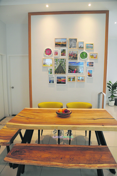 原木餐桌由雨树木板裁剪而成，配搭照片墙的生活故事丰富空间。