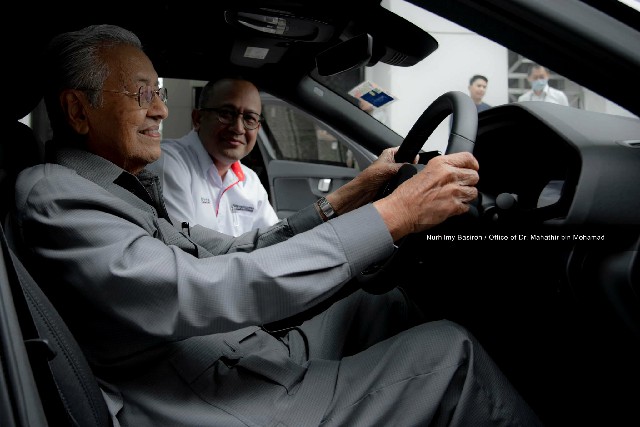 马哈迪在官员陪同下试驾电动车。