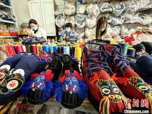 
<b>山东菏泽传统布鞋</b>－－工人周四在中国在山东省菏泽市牡丹区安兴镇一家布鞋作坊制作传统布鞋。目前，山东省菏泽市牡丹区安兴镇的布鞋制作产业形成规模，“虎头鞋”“凤眼鞋”等传统布鞋俏销市场。（中新网）