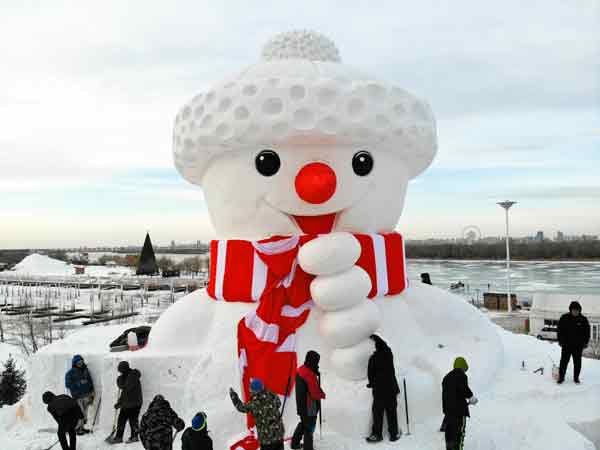 <b>巨型雪人</b>－－　中国一座正在搭建的巨型雪人，周二在松花江哈尔滨段江畔“亮相”。据报导，这座大雪人设计总长13公尺、宽10公尺、高18公尺，计划用雪量为2000立方公尺，造型可爱、憨态可掬。（新华社）
