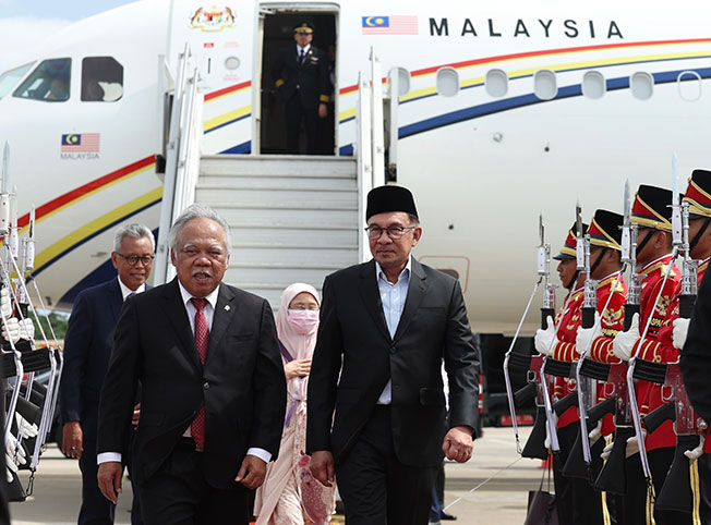 安华（右起）抵达耶加达苏加诺─哈达国际机场，印尼公共工程和公共住房部长巴素基到场接机。
