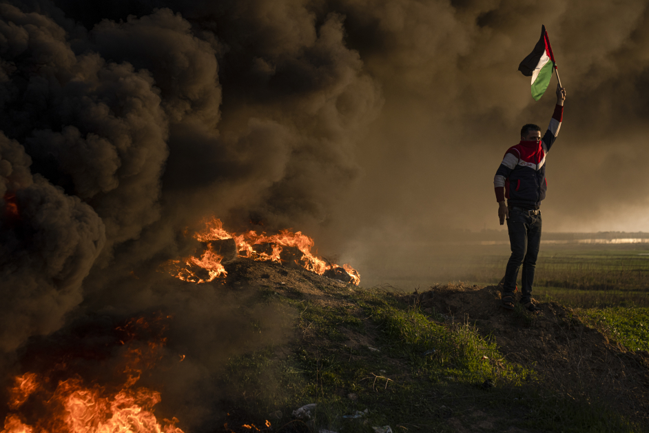 巴勒斯坦人26日在加萨东部与以色列的边界围栏焚烧轮胎并挥舞国旗，抗议以色列对杰宁的军事突袭。（美联社）