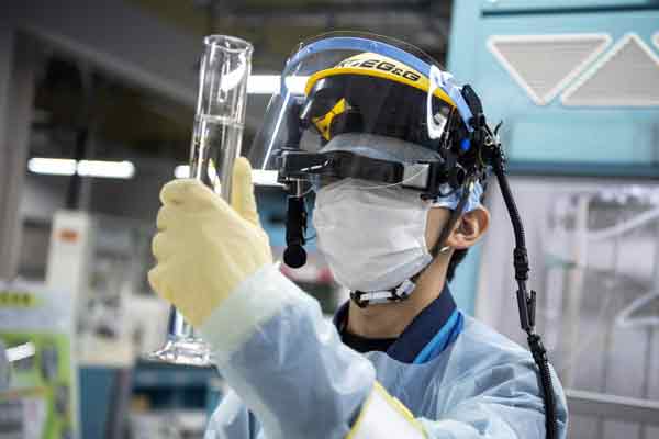 一名员工去年3月在福岛第一核电站对受污染水样进行氚测量。（法新社）