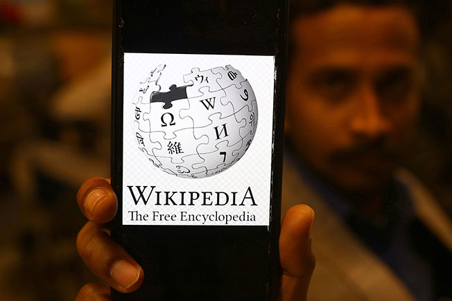 卡拉奇一名男子周六用手机展示维基百科页面。（欧新社）