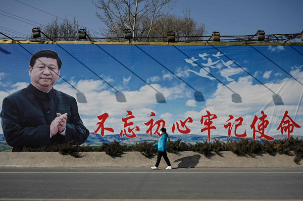 北京街头可见习近平肖像和标语的告示牌。（法新社）