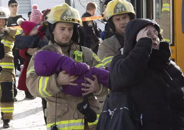 救援人员抱小童离开。