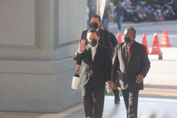 旺赛夫(中)向在场等待的媒体招手。