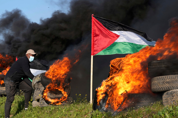 示威者周三在纳布卢斯焚烧轮胎泄愤，抗议以色列陆军突袭巴勒斯坦。（美联社）