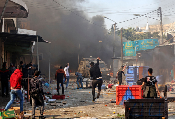 巴勒斯坦民众在西岸城市纳布卢斯，与以色列安全部队人员发生冲突。（法新社）