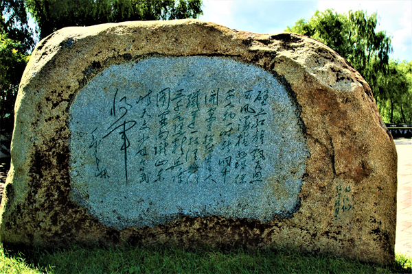 毛泽东 写给丁玲的词《临江仙》，行草字迹在巨石上龙飞墨舞。