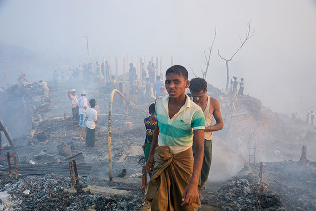 罗兴亚难民周日在被烧毁的营地中，寻回自己的东西。（欧新社）