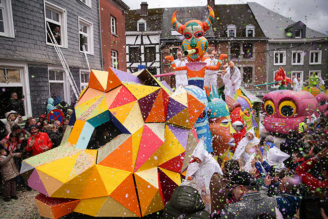 比利时斯塔沃洛狂欢节－－3月19日，在比利时东部的小城斯塔沃洛举行的狂欢节游行上，表演者向人们抛洒碎纸片。斯塔沃洛狂欢节是比利时最具特色的狂欢节活动之一。狂欢节期间，身着白色教士服，头戴胡萝卜状长鼻子面具的“白衣人”要用吹起的猪膀胱，敲打路人的头，并向人们抛洒碎纸片。（新华社）