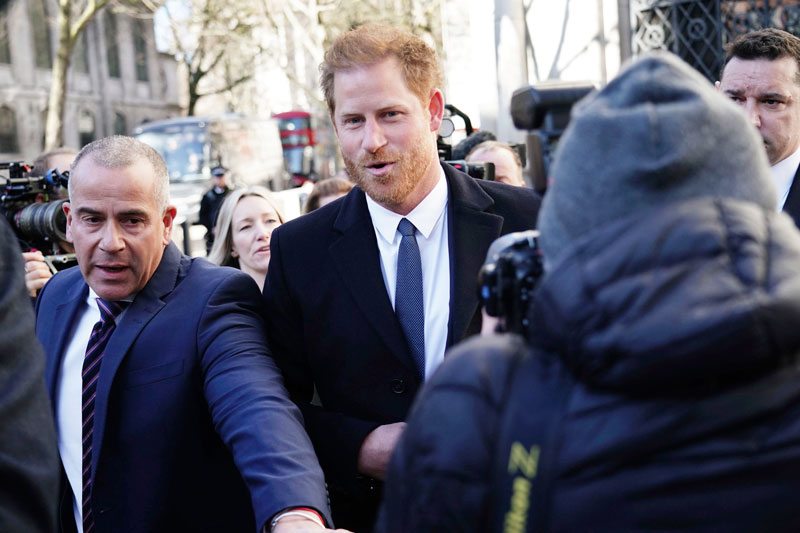 哈里王子周一抵达伦敦法院，受到媒体争相采访。（美联社）