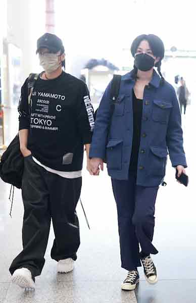 王菲和谢霆锋在机场公开牵手。