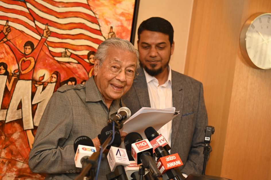 马哈迪在记者会上宣读安华作出的指控，右为其律师拉菲克。