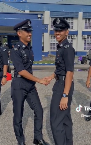 双胞胎兄弟互相道贺成为正式警察。