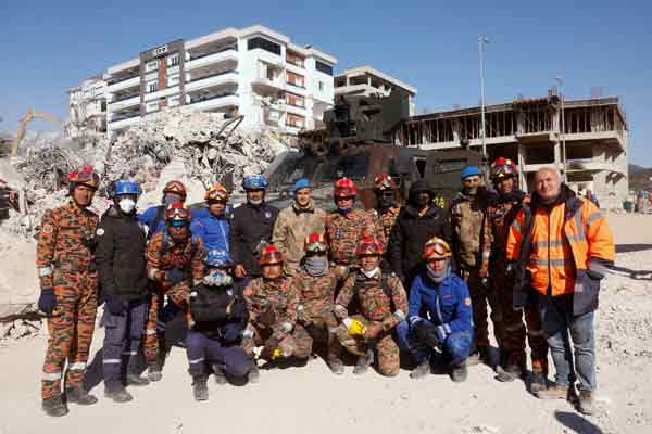 凯鲁（后排右5）与大马特别灾难援助和救援队（SMART）、民防部队、大马消拯队和土耳其军人，合照留念。
