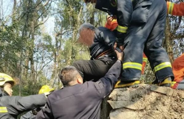在8公尺高的山坡上，老先生在众人的帮助下获救。