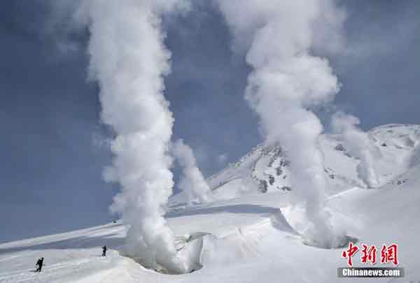 <b>火山口喷蒸汽</b>－－在日本旭川，滑雪者周三观看蒸汽从的火山喷气孔中喷出。通常情况下，只有在冬天，人们才能接近火山喷口，因为整座山都被积雪覆盖。（中新网）
