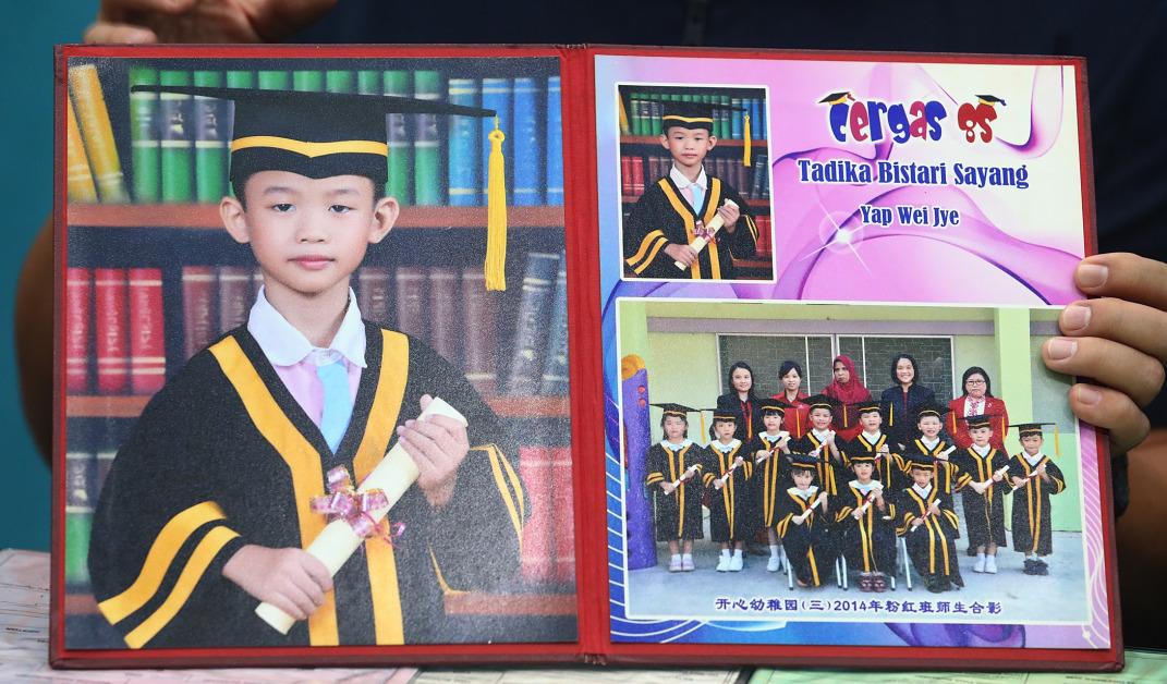 叶伟杰在6岁那年，幼稚园毕业时身穿毕业袍的照片。