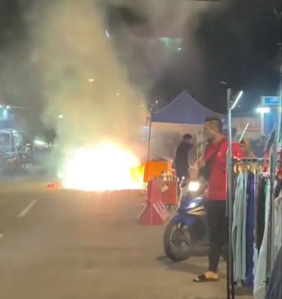 疑烟花爆竹被意外点燃，导致摊位瞬间起火，烟花四处燃放和爆炸。