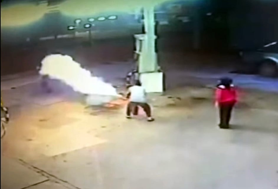 油站业者用灭火器扑灭伤者身上的火。