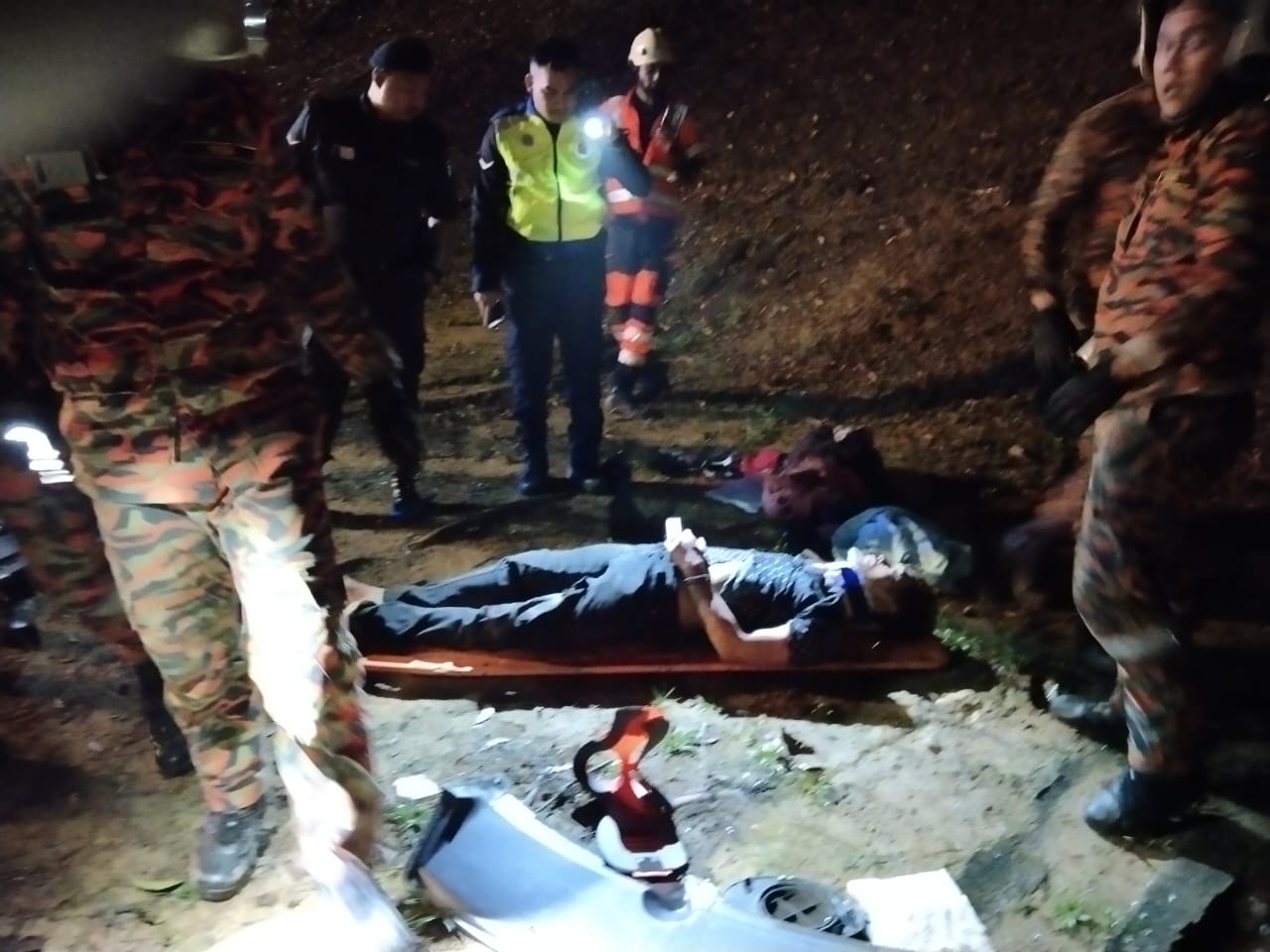 其中一名受困男子获救后，躺在担架上由救护车送院。