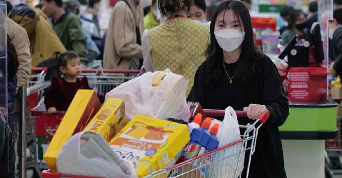 一名女子1月在河内的一家超市戴着口罩购物。