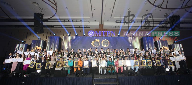 得奖者领着奖状、奖杯,与各位嘉宾分享喜悦;前排坐者左7起为阿都拉扎、陈文松、聂阿迪、杨国伟、诺阿芬迪和努鲁阿兹哈。