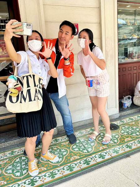 前进党曼谷第1区5号候选议员张光明上街拜票，民众热情要求玩自拍。