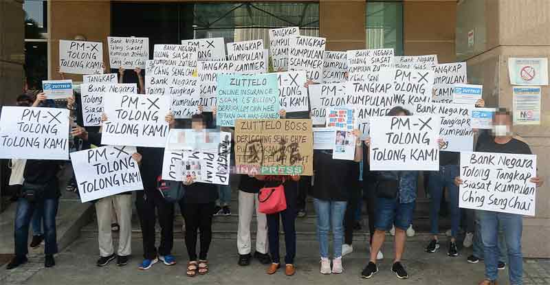 约百名受害者周三（3日）早上在该中心布城总部外举起纸牌，要求执法单位对便宜采取行动。