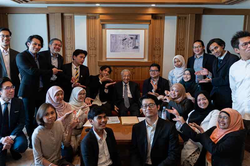 马哈迪（中坐者）在东京与旅日大马人见面、交流后拍大合照。