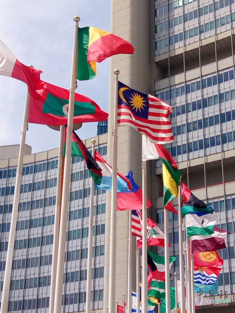 旗海飘飘的广场上，马来西亚的辉煌条纹与各国旗帜并列飞扬。