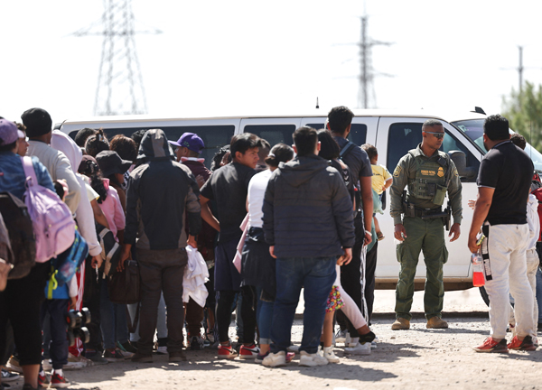 寻求庇护的移民，周三等待美国边境巡逻局官员处理手续。（法新社）