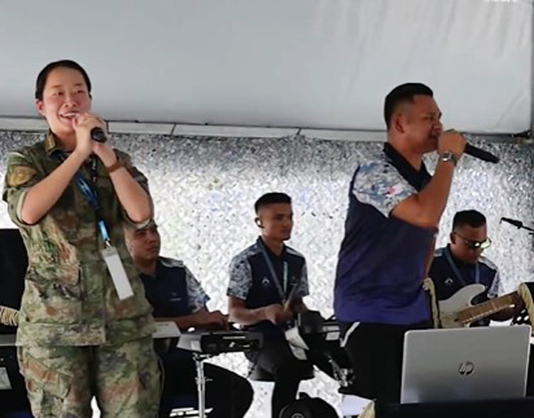 大马巫裔海军与一名中国女海军，台上合唱《海阔天空》。