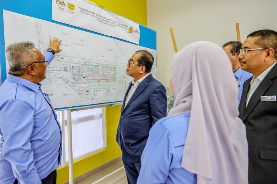 莫哈末卡立诺丁(中)聆听马来西亚砂拉越大学人员讲解该大学教学医院建设情况。