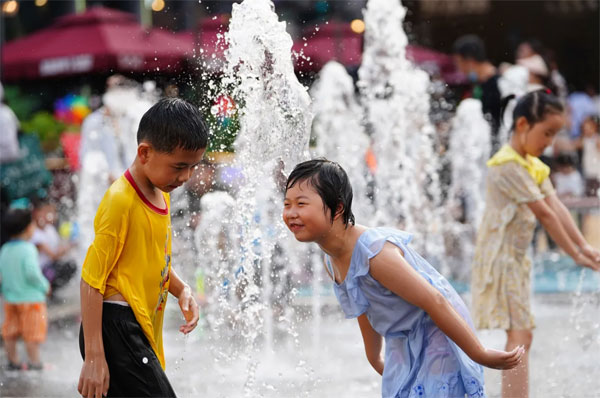 北京市的小朋友在路上玩水消暑。