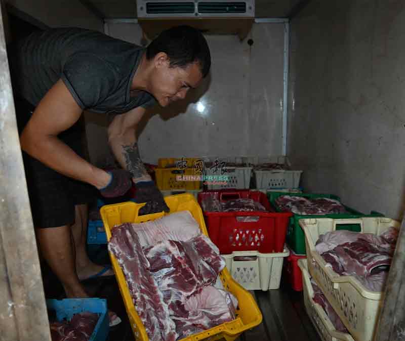 屠宰场工友把处理好的猪肉送到猪肉店及顾客。

