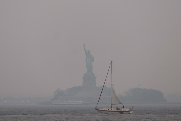 位于纽约市哈德逊河口的自由女神像，被烟霾蒙上一片阴影。（法新社）