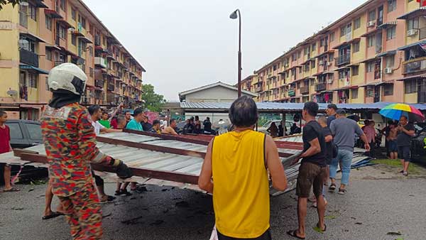 在消拯员和当地居民的协助下，将掀翻的屋顶取走。