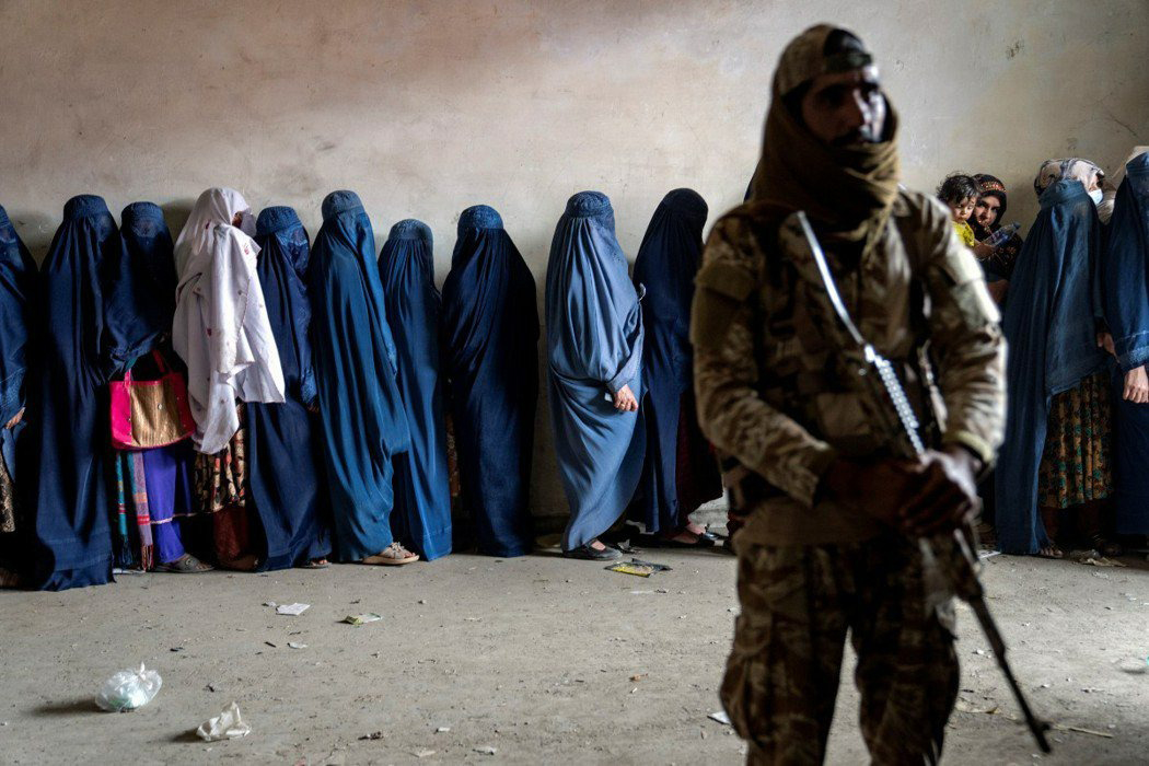 塔利班严格限制阿富汗女性的工作、教育与行动自由。图为女性身穿罩袍排队等候人道组织发放粮食。