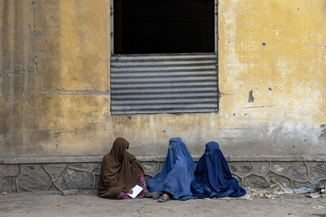 阿富汗女性身穿罩袍，等候人道组织发放粮食。 
