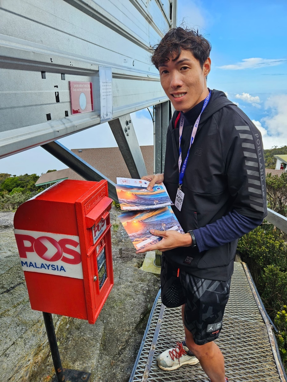 神山火炬队成员黄嘉驹在神山把明信片投入马来西亚最高的邮箱内准备寄发。