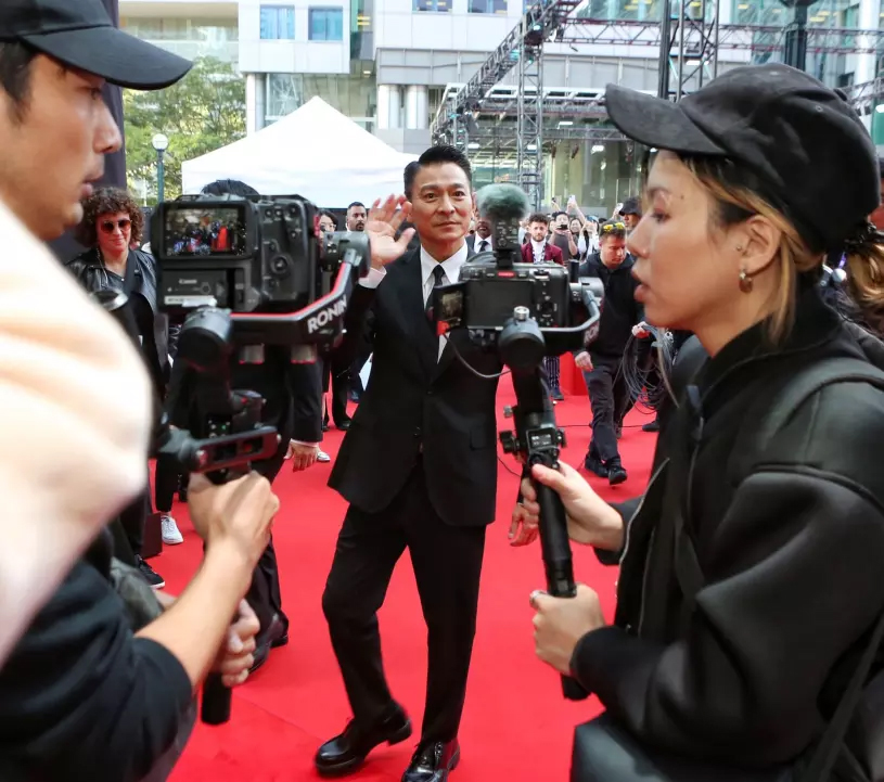 刘德华与现场粉丝挥手,表现亲民。