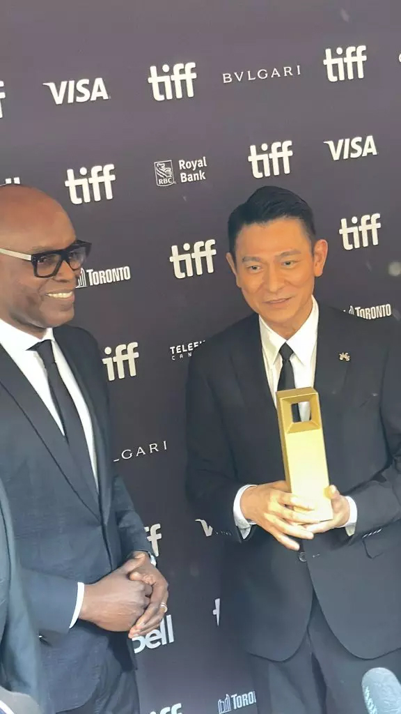 刘德华从TIFF主席卡梅伦贝利(Cameron Bailey,左)手中接过奖杯,感谢大家支持。