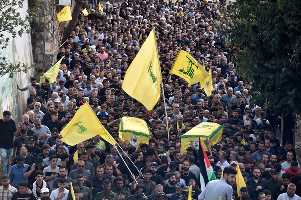 周二在黎巴嫩南部基尔贝特塞尔姆村，真主党成员为2名被以军杀害的战士举行葬礼期间，抬棺游行，抗议以色列。（欧新社）
